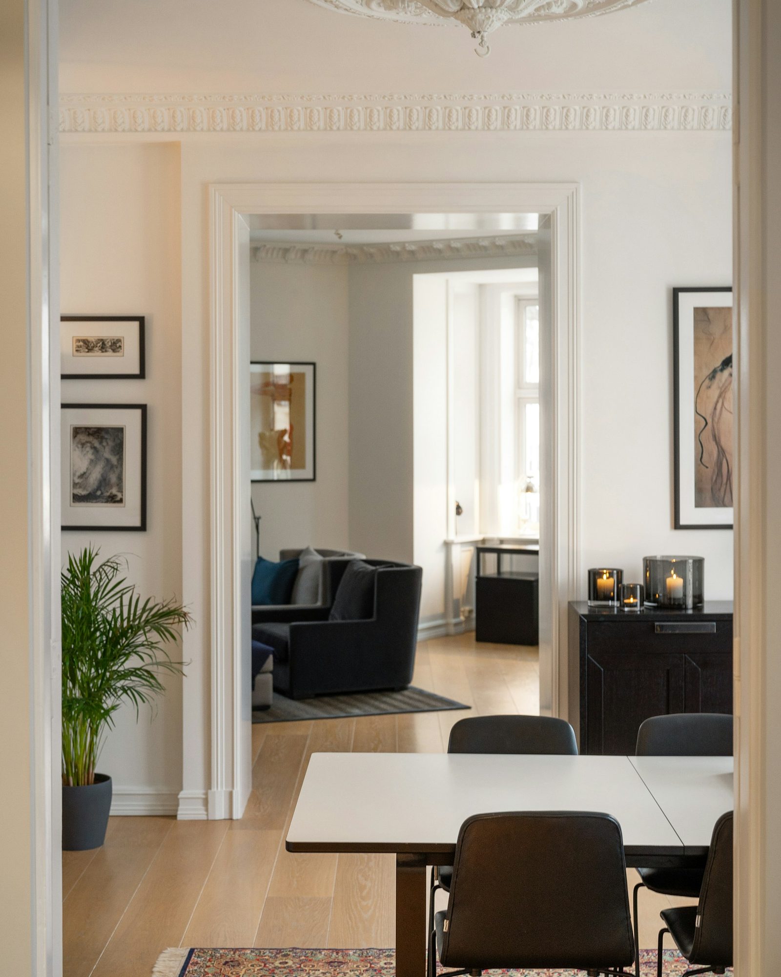 Softly lit modern living room with a textured neutral wallpaper feature wall, tailored bench seating, and a warm wood floor